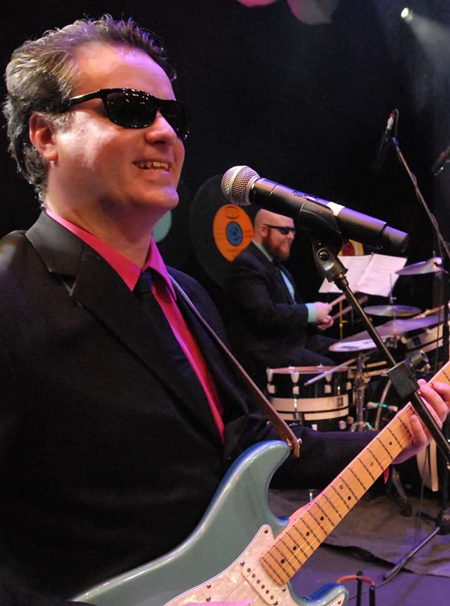 Image of Ben wearing shades while playing live